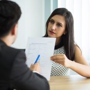 serious-young-female-manager-showing-contract-partner_1262-18058